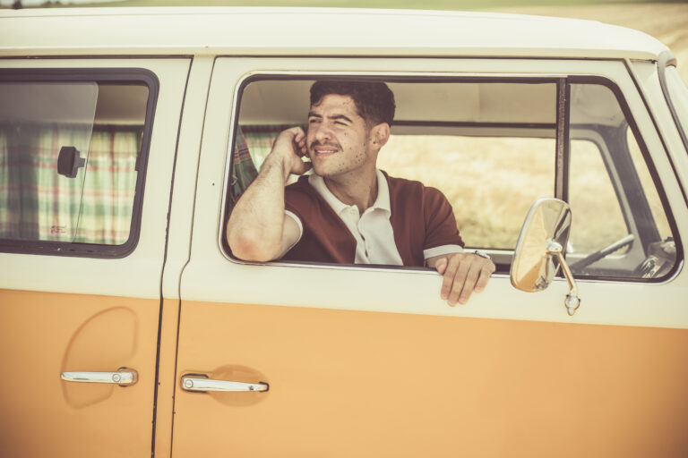 Homme téléphonant, vu à travers la fenêtre d'un combi Volkswagen